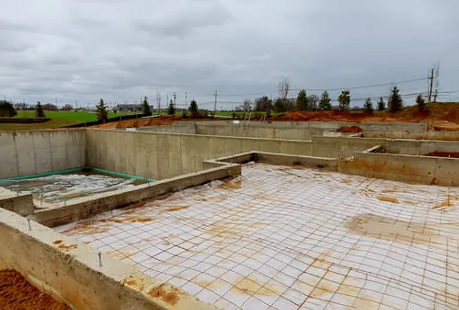 Reinforced concrete slab foundation under construction with formwork and steel reinforcement in place